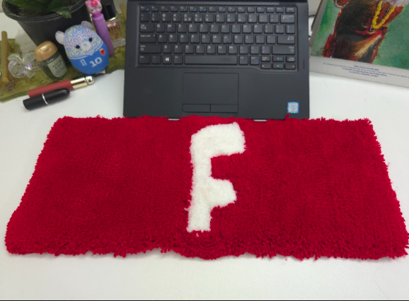 Custom keyboard rug beneath a laptop on a modern workspace desk
